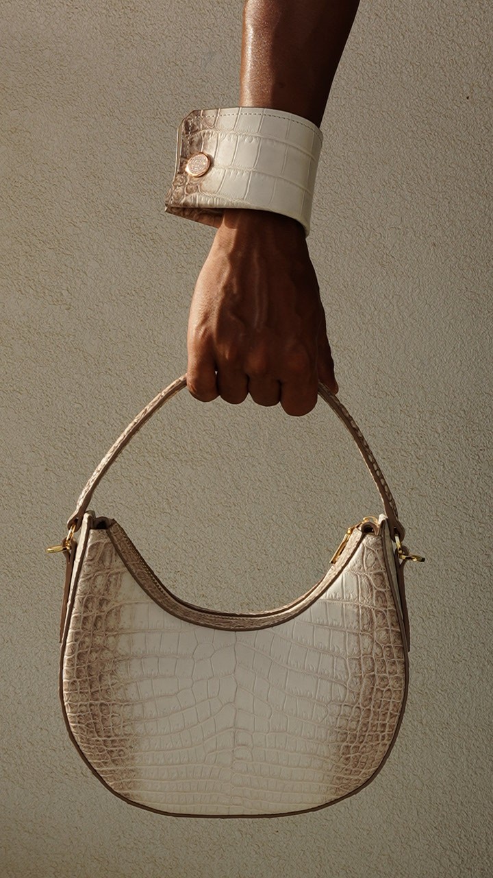 Pale VALEUR cuff worn while carrying a coordinating pale leather bag